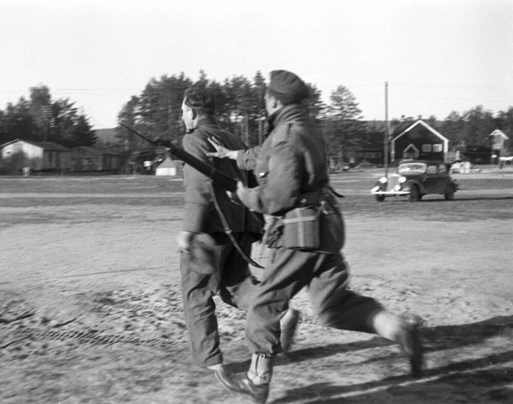 <b>ELVERUM, FREDSDAGENE 1945:</b> Engelske troppers razzia i tyskerleiren på Terningmoen. Tysk soldat jages av en engelsk.