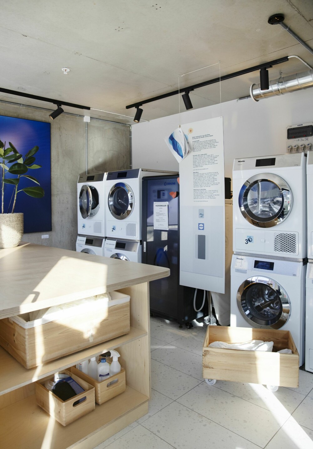 <b>NABOLAGSVASKERIET:</b> I første etasje har Obos Living Lab sammen med Common Vask bygget et fellesvaskeri for beboerne. Her står vaskemaskiner og tørketromler, bygget med bærekraftig teknologi. Man booker vask digitalt og velger enten å vaske selv, eller å få tøyet hentet, vasket og levert på døren.