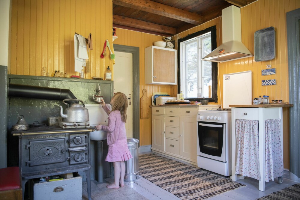 KJØKKEN: Tilde på snart fem år elsker å være i Egilstua hos tante og onkel. Nå skal hun fylle veslekjelen sin og vanne blomstene ute. Kjøkkenovnen er kjøpt brukt, i tillegg har de en gassovn for å lage mat på.