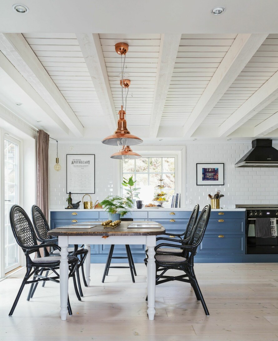 ARVET KJØKKENBORD: Kjøkkenet var ganske nytt da familien flyttet inn, men de har oppgradert på budsjett, lagt nye fliser og skiftet benkeplater. Kjøkkenet kommer fra Epoc. Vifte og ovn fra Smeg. Den lille pendellampen i hjørnet er fra Clas Ohlson. Spiseplassen består av et arvet bord, og Ikea-stoler kjøpt brukt på nettet.