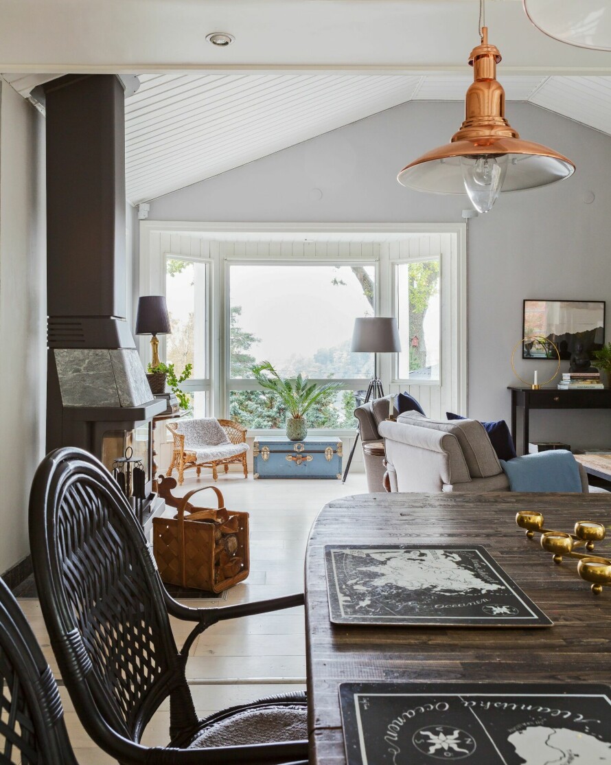 LYST I SPISESTUEN: De store vinduene i karnappet henter naturen inn i rommet som brukes som stue og spisestue. Spisebrikkene på bordet er fra Svenskt Tenn.