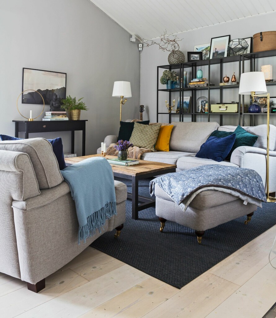 SYMMETRISK OG BALANSERT: Saras feng shui-interesse gjør at hun ønsker å balansere innredningen. De symmetrisk plasserte gulvlampene er kjøpt på auksjon på nettet. Howardsofa fra The Sofa Store. Teppe fra Ikea, sofabord fra Confident Living. Lysestakene på bordet er loppefunn, vasen fra In & Finn. Sofaputer fra Mio og H&M Home.