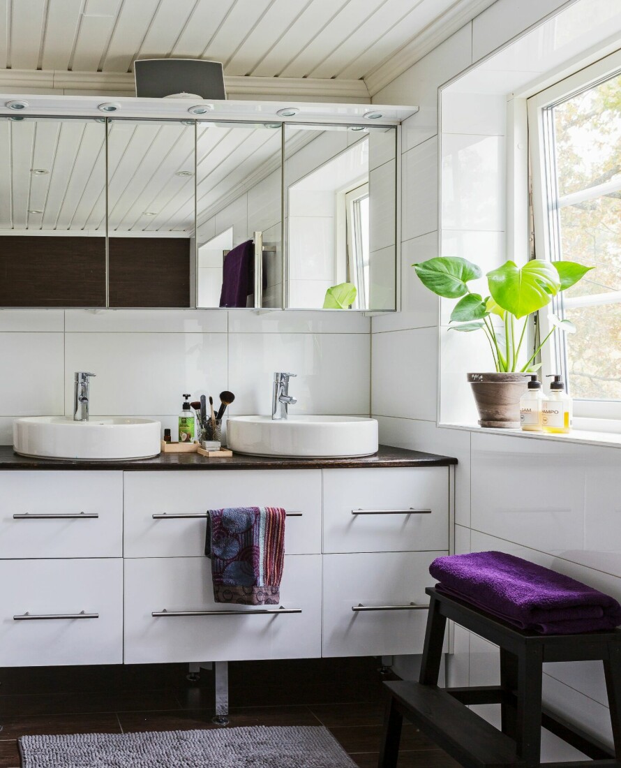 STILIG BAD: Selv fra badet er det utsikt til naturen utenfor. Baderomsmøbel fra Svedbergs, teppe og pall fra Ikea.