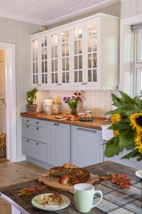 KJØKKENINNREDNING: Kjøkkeninnredningen er malt i to ulike farger; det skaper god harmoni. Det rustikke kjøkkenbordet passer godt inn i stilen.