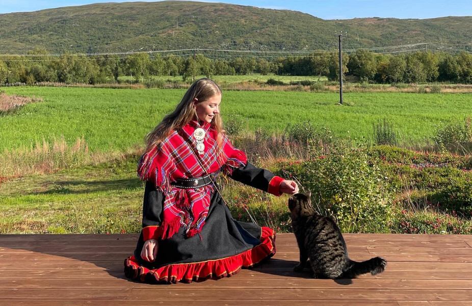 <b>HJEMME:</b> Vibeke i tradisjonell, koksgrå Polmak-kofte med katten Emma. Bildet er tatt på hjemplassen Árbanatnjárga/Holmesund i Tana.