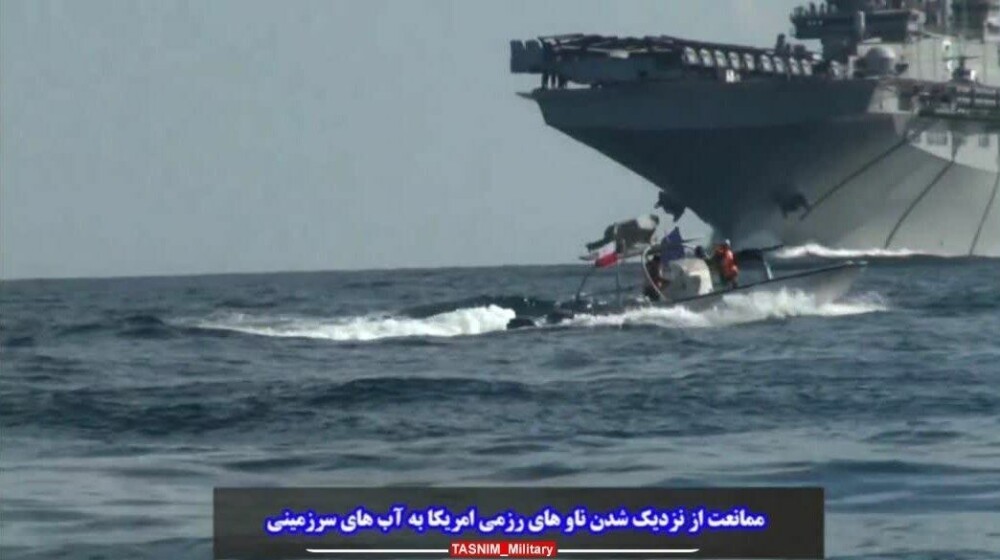 <b>KONFRONTASJON</b> En hurtigbåt fra Revolutionary Guard (IRGC) beveger seg nær USS Bataan. IRGCs marinekommandør kontreadmiral Ali Reza Tangsiri sa at helikoptere fløy utenfor det amerikanske helikopterskipets flydekk, men ble tvunget til å lande kort tid etter da IRGC-styrkene som kontrollerte Hormuzstredet ga en advarsel og Zolfaqar-flotiljen satte ut fartøyer til stedet.