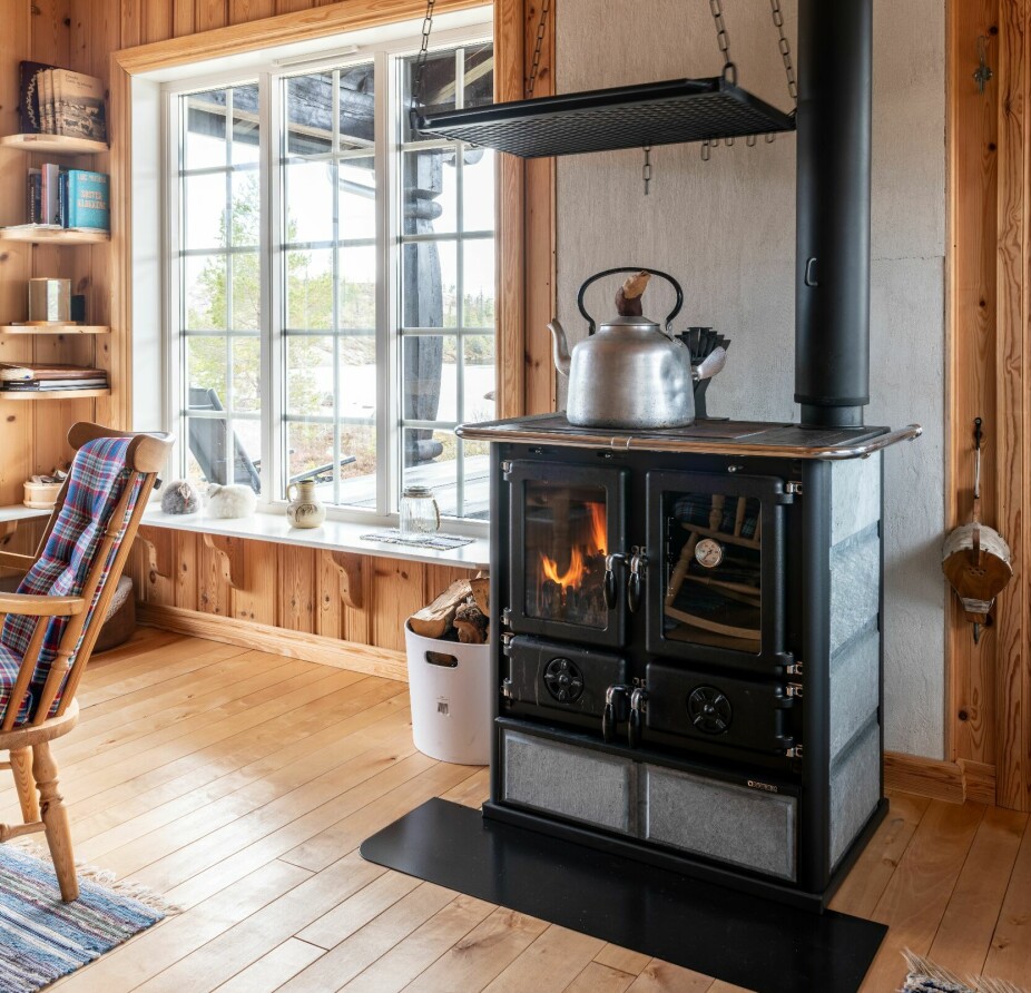 FULL UTNYTTELSE: I denne hytta ser vi at den klassiske vedkomfyren fra italienske Nordica er godt utnyttet; den gir god varme til rommet, på kokeplaten kan det varmes vann og stativet over ovnen er praktisk for klestørk.