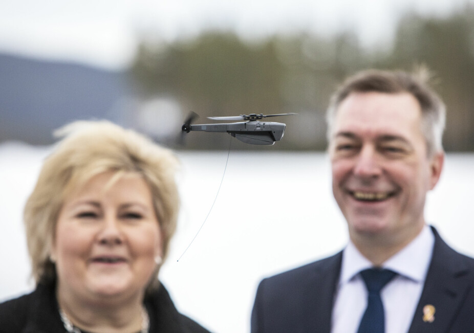 <b>KNØTTLITEN: </b>Daværende statsminister Erna Solberg og forsvarsminister Frank Bakke-Jensen beundrer en knøttliten Black Hornet 3-drone i 2019.
