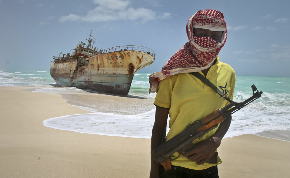 <b>PIRATREIR:</b> I dette arkivbildet fra 2012 står den somaliske piraten Hassan foran et skip som endte opp som vrak på stranda. I lang tid var pirat­virksomhet en svært lukrativ industri i det borgerkrigs­herjede landet.