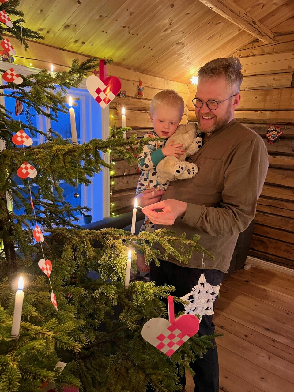 EKTE LYS: Tor-Evert tenner julelysene sammen med Emil. For å stå i stil til fjellgården må det selvsagt være ekte stearinlys på juletreet. Emil følger andektig med.
