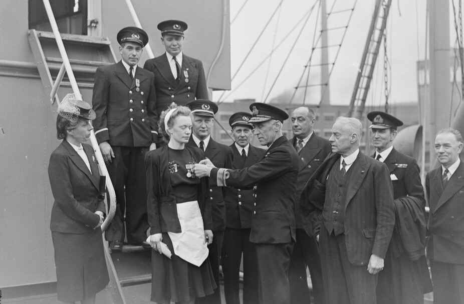 MARGITS UNIFORM: Salongpiken Margit mottar hederstegnene for sin innsats under «selvmordskonvoien» til Malta av en britisk admiral og en representant fra den norske regjeringen.