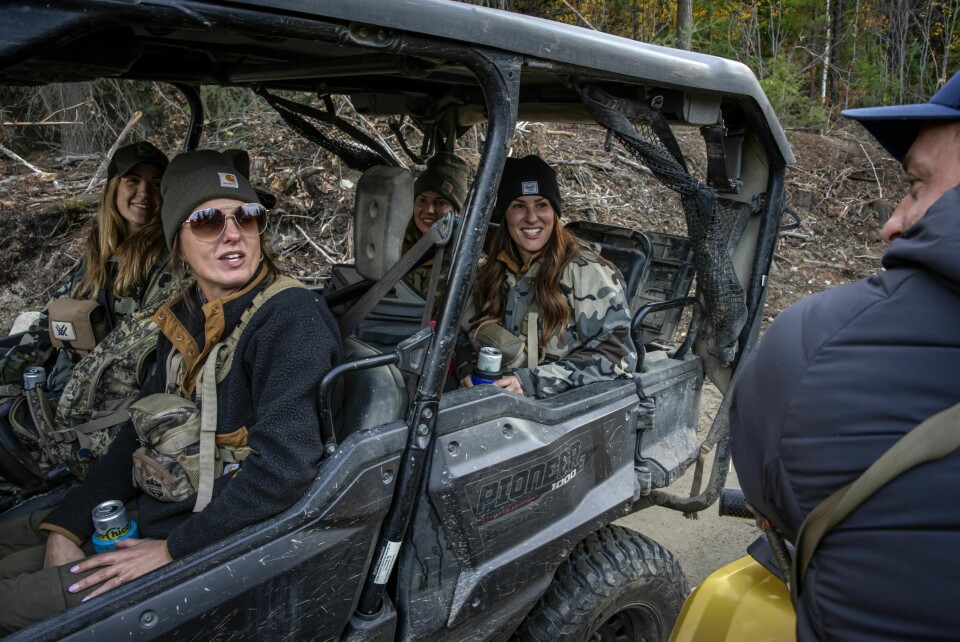 DAMER FOR ØL OG JAKT: Mange utenforstående finner bygda og levesettet attraktivt. Her snakker Justin med fire damer fra storbyen som kommer hit så ofte de kan for å drikke øl og jakte rådyr. Innbyggerne er litt bekymret for at altfor mange skal oppdage syndens paradis.