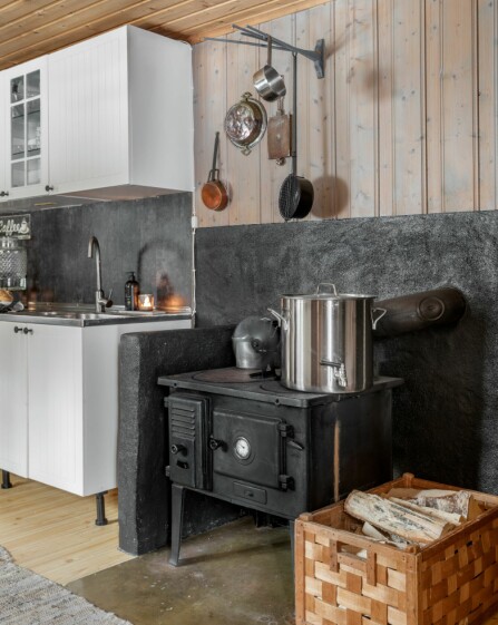 VEDFYRT KJØKKENOVN: På kjøkkenet står det en svartovn som brukes til så vel kaffekoking som rundstykkesteking og oppvarming av vann. Men det hender at Ingeborg tar med seg oppvasken hjem i en balje.
