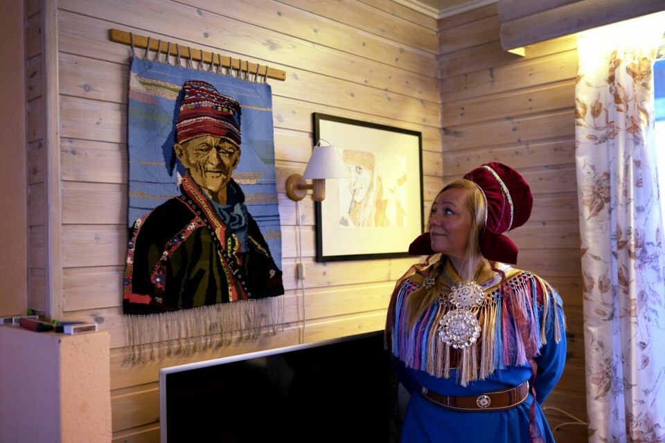 BESTEFAR: På besøk hjemme hos faren sin i Kautokeino står Ellen Kristina foran et veveri som viser ansiktet til bestefaren hennes.