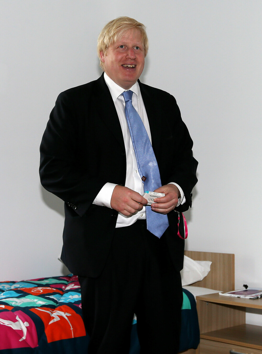 <b>SUVENIR-GUMMI:</b> Daværende ordfører i London, Boris John­son, viser frem standard­inn­redningen på deltager­rommene før OL i London i 2012; en pakke med kondomer, smykket med lekenes offisielle logo.