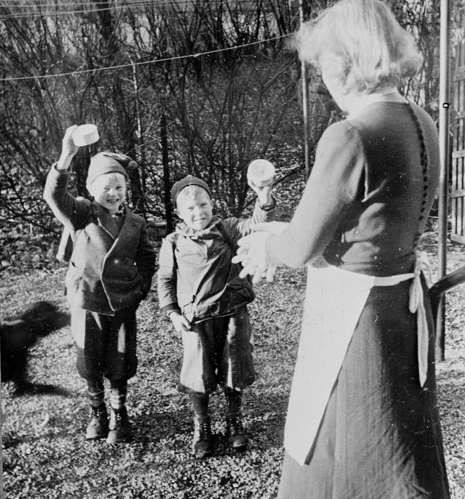 <b>HJELP FRA SVERIGE:</b> Den svenske hjelpe­aksjonen for Norge, Svenska Norgehjälpen, organiserte bl.a. mat­leveranser til institusjoner i årene 1942–45. Her kommer to skolegutter hjem til mor og vinker strålende fornøyde med smørbrød som de har fått på skolen.