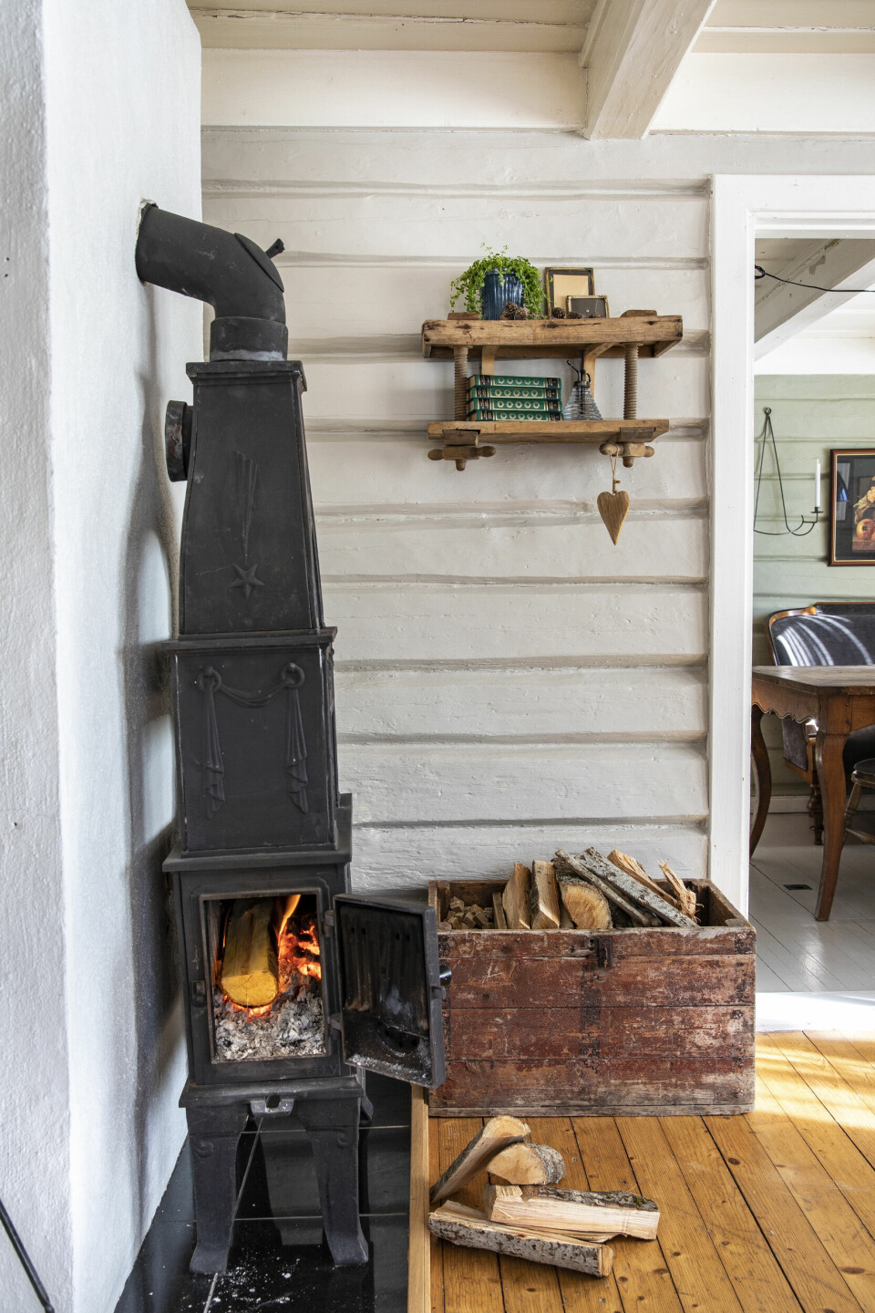 SJARMEN MED VEDOVN: Den gamle svartovnen varmer godt i stua, og at veggen er helt skjev syns Vibecke bare er sjarmerende. Hun har en vedovn i stua og en på kjøkkenet, og det trengs i et gammelt hus.