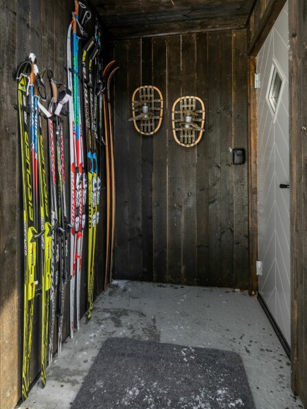 KLART FOR TUR: Rett utenfor hytta er det skiløyper, og da er det praktisk å ha skiene lett tilgjengelige i inngangspartiet. Gamle truger pynter opp på veggen.