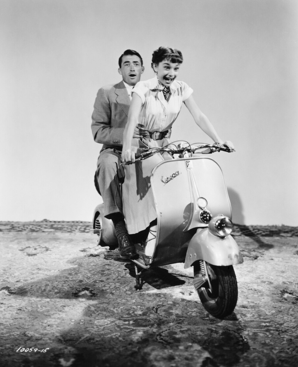 <b>PRINSESSE ANN I STYRINGEN:</b> Bildet er tatt i 1953 under en øvelse til en mopedscene i den romantiske komedien Roman Holiday. Motspiller Gregory Peck henger med som best han kan, med rollefigur Princess Ann i styringen.