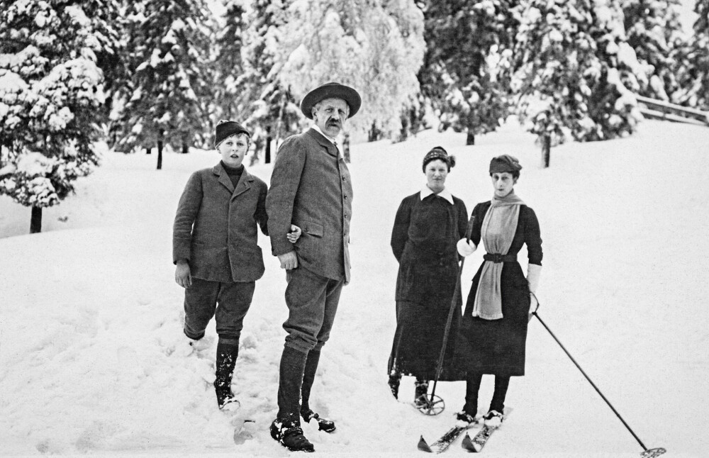 <b>I GOD SKOLE:</b> Dronning Maud på skiskole hos Fridtjof Nansen, som her står med kronprins Olav i armen. Dronningens måte å dandere ­skjerfet på skapte mote i skiløypa.  