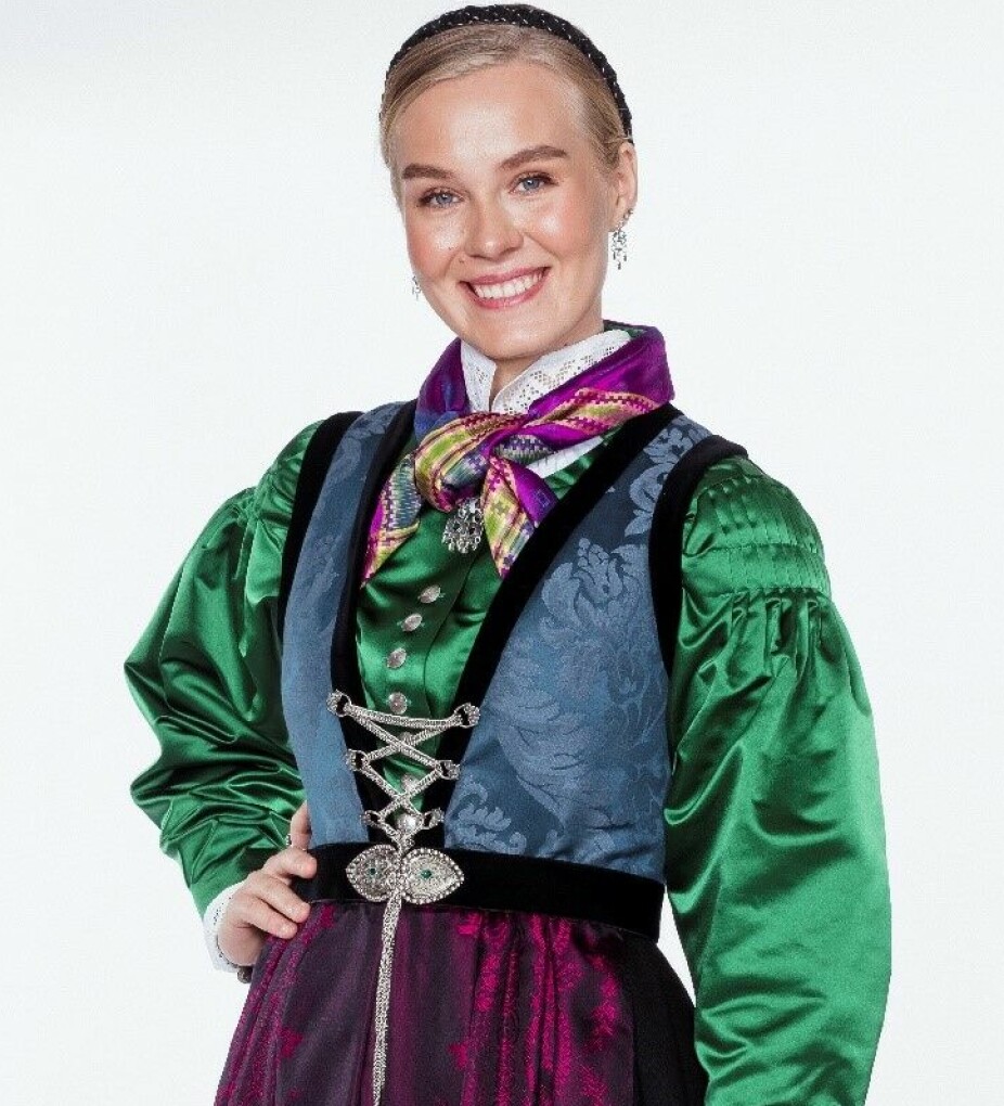 KNÆSJ GRØNN: – Vi selger mye silkeskjorter, sier Ellen Øverland hos Heimen Husfliden. Dette er en bunad fra Sogn med grønn silkeskjorte og rosa silkeforkle.