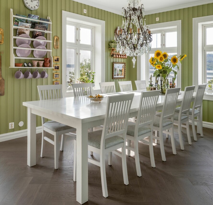 GRØNT ER SKJØNT: Kjøkkenveggene er malt i fargen 8109 Aprilgrønn fra Jotun. Det store kjøkkenbordet i massivt tre som måler 3,20 x 1,20, fikk de laget hos kjøkkenprodusenten, og stolene ble kjøpt i hui og hast i Sverige for at de skulle ha sitteplasser til julemiddagen. Lysekronen ble også kjøpt da huset var nybygget.