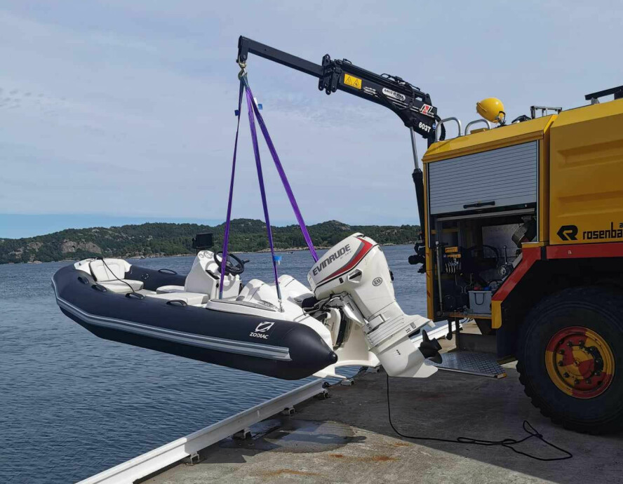 SJØ OG LAND: Brannbilens egen kran sjøsetter den medbrakte båten.