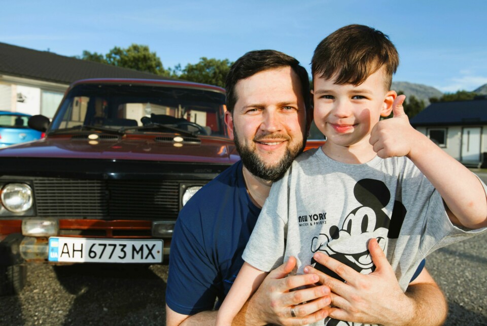 TIDLIG KRØKES: En smørblid og stolt Dima (5) setter tommelen entusiastisk i været for pappa Evgenijs Lada. Bilen fraktet familien og noen få eiendeler fra utbombede Mariupol i Donbass til Sandnessjøen.