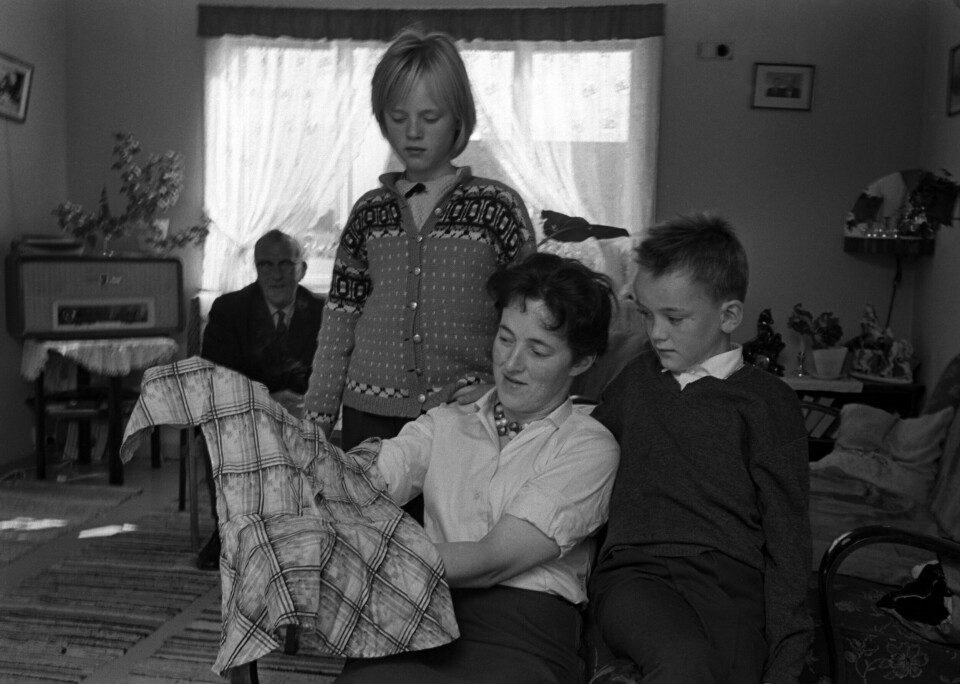DRAMATISK: Hjemme hos Svanhild Hartvigsen i 1963 hvor hun viser to av barna sine, Wenche og Arild, kjolen hun hadde på seg da hun ble tatt av en havørn i 1932.