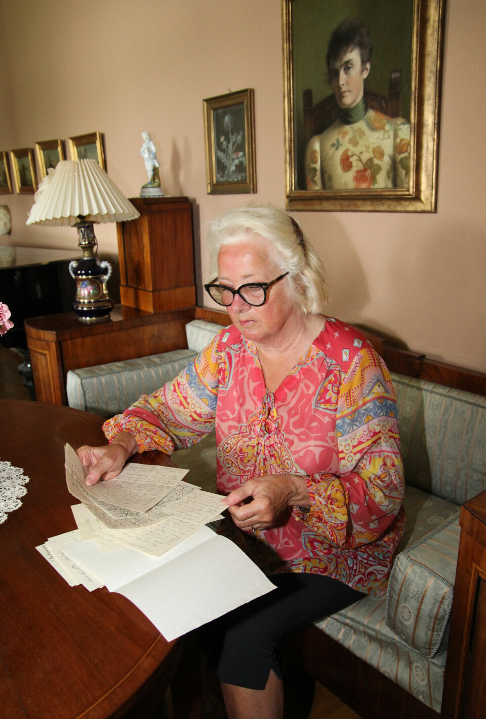 KVINNEKRAFT: Lise Thorsø Mohr lar seg oppsluke av den historiske kvinnekraften på herregården. Hun har bidratt til at Dikkas niese Katti Anker Møller (maleriet på veggen) har blitt hedret med en statue i Fredrikstad.