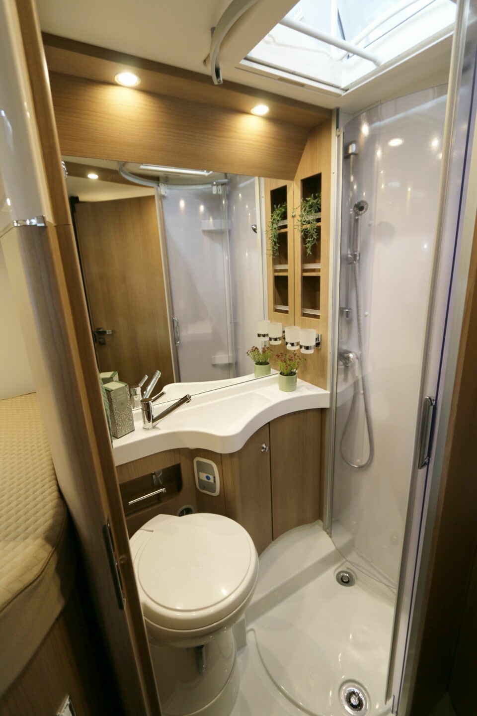 SAMLET: Toalett og dusj i samme rom. Separat runddusj, speilskap, servantskap og mange hyller.