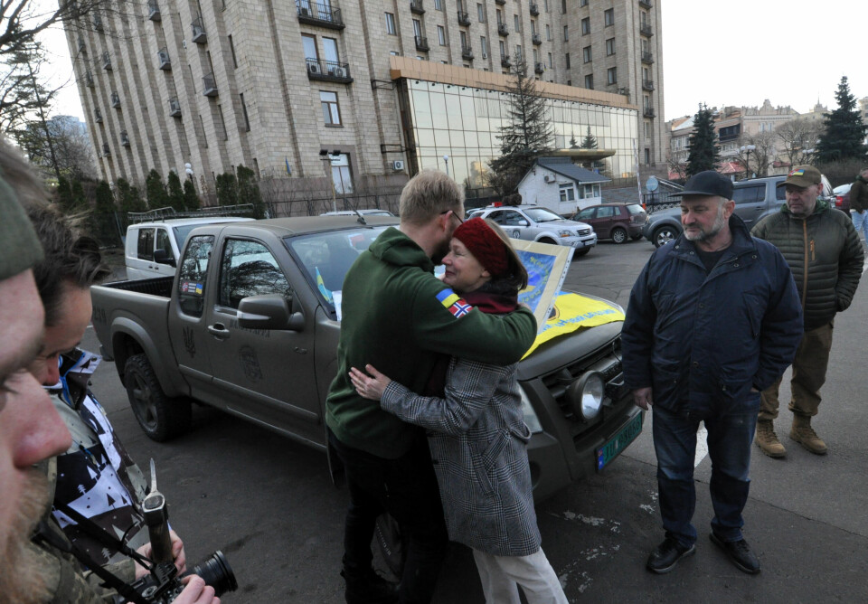 GAVER OG BARNE-TEGNINGER: Leder i Ukrainian Freedom Convoys, Ole Kvåle, får en god glem av en av de frivillige ukrainerne som har møtt frem. Hun har med seg en rekke barnetegninger hun deler ut til sjåførene. I bakgrunnen ser vi Hotel Ukraina og parken der dype tragedier har utspilt seg.
