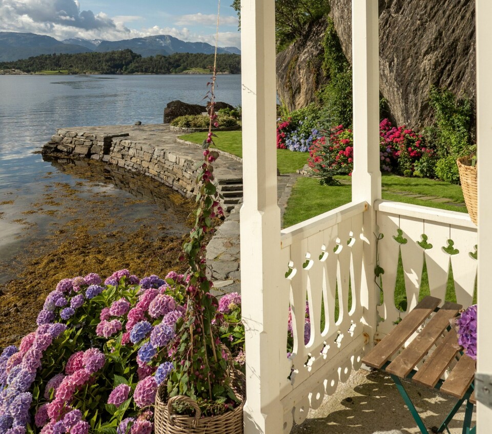 MORGENPLASS: Doble dører leder ut til denne terrassen midt på huset med trapp ned til uterommmet. Detaljerte utskjæringer og mønedekor er typisk for sveitserhus.