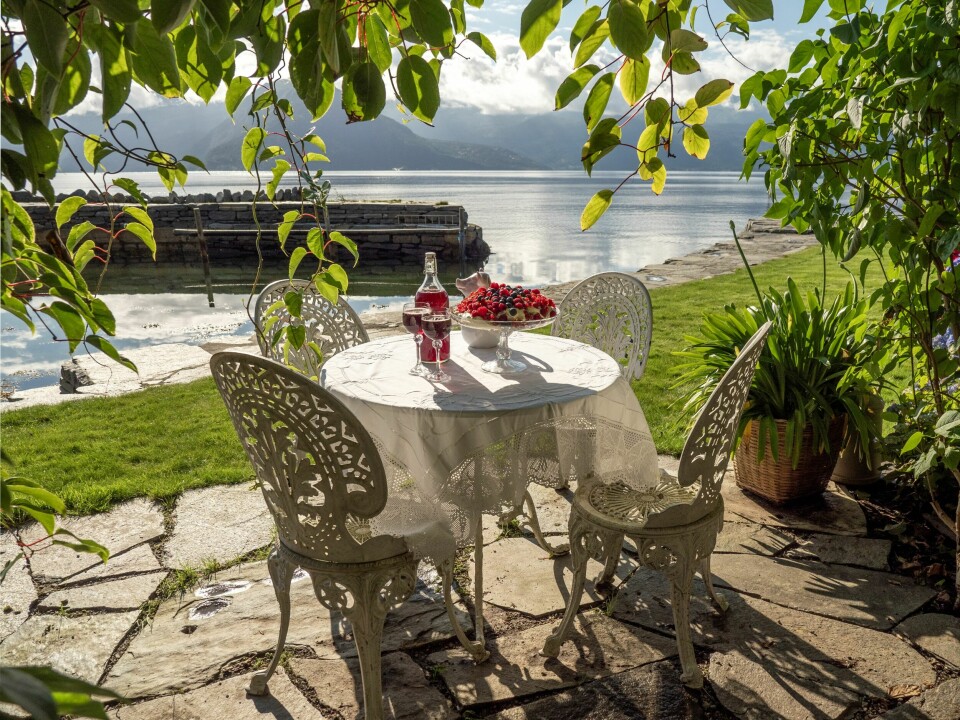 IDYLL: De romantiske smijernsmøblene er kjøpt i en antikvitetsbutikk i Danmark. Fra denne nydelige sitteplassen nede i fjæra er det nydelig utsikt mot Folgefonna og fjellet Samlanuten.