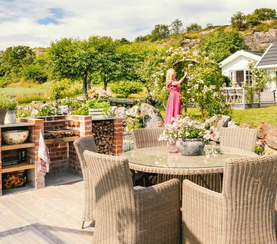 UTEKJØKKEN: Den selvmurte grillen har paret mye glede av. Utemøbler fra Plantasjen. Kine er fornøyd med portalen, som er kledd med roser.