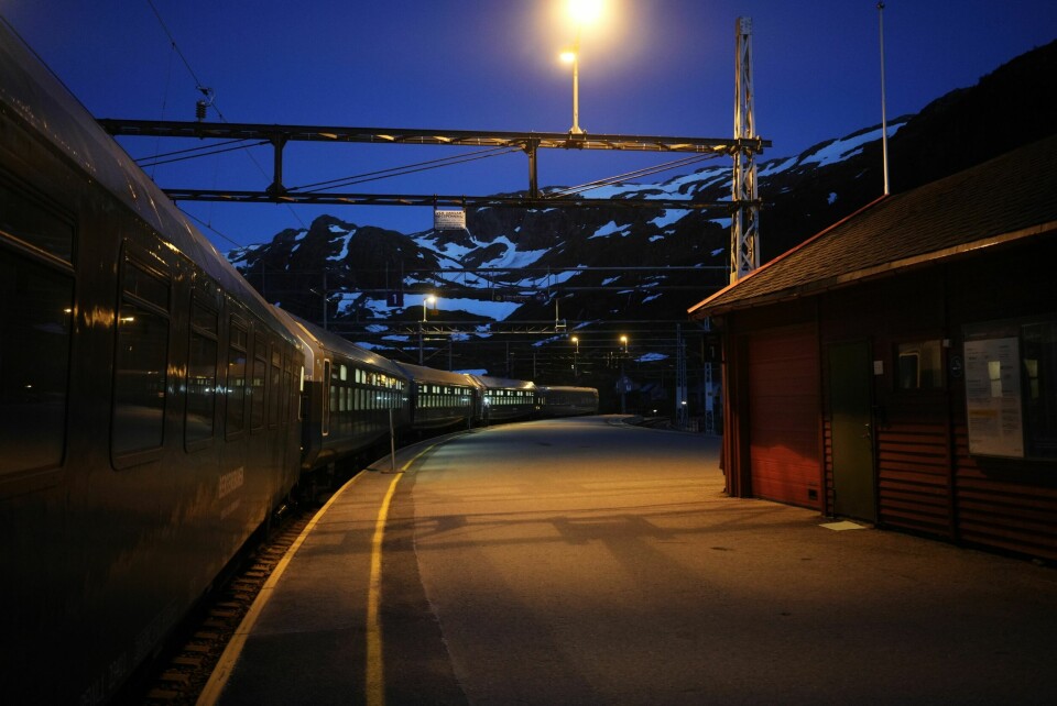 ALENE I NATTEN: Overkonduktør Jan Kongsund signaliserer klart til avgang fra sovevognseksjonen i nattoget. Turisttrengselen på Myrdal stasjon på dagtid virker med ett veldig fjern.