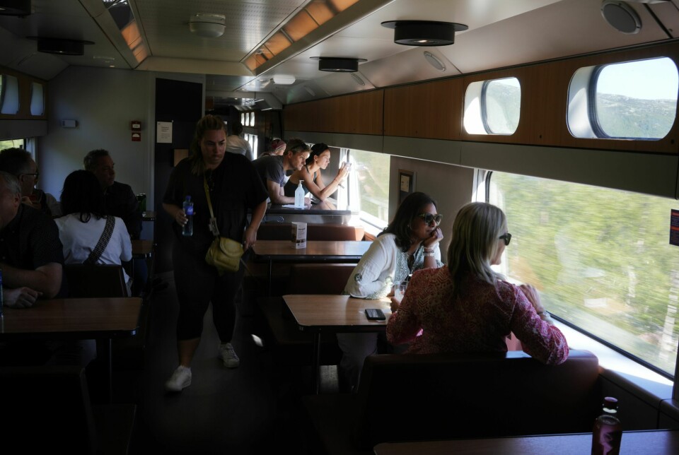 KONTRAST: Turisttogene over Hardangervidda har gjerne med seg mer enn 400 mennesker over vidda på dagtid sommerstid. Begeistringen er stor hos Sarah Smith og Guy Furniss fra England (ved vinduet midt på bildet). Utsikten fra toget blir en solid trøst etter at Sarah ble skadet i Oslo og fotturen til fjells måtte avlyses. Men den lyse sommernatten trodde de at de måtte kjøre nordover for å oppleve.