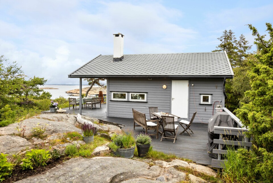 I ETT MED TERRENGET: Deler av den store terrassen som omkranser hytta er tilpasset terrenget. På kjøkkensiden mot sydøst er plattingen innredet med utekjøkken, grill og spiseplass.