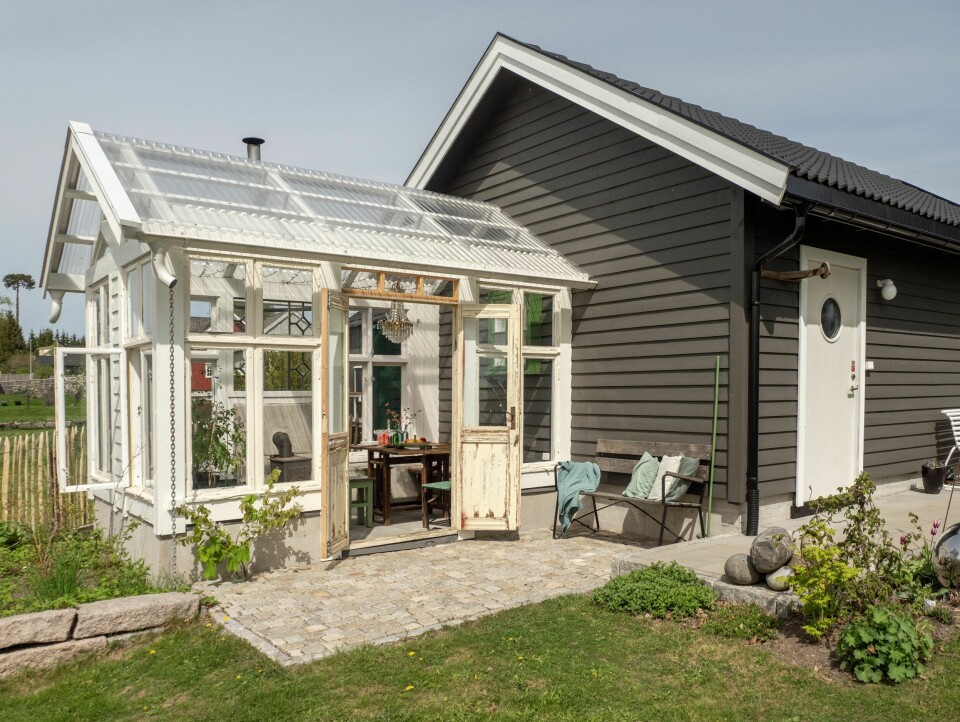 GJENBRUKSDRIVHUS: På en tømrerjobb kom Martin over en haug gamle vinduer som skulle kastes. De har nå blitt til dette nydelige lille huset på ca. 12 kvadratmeter som brukes hele året. Plassen foran er rammet inn av gammel brostein fra Oslo.