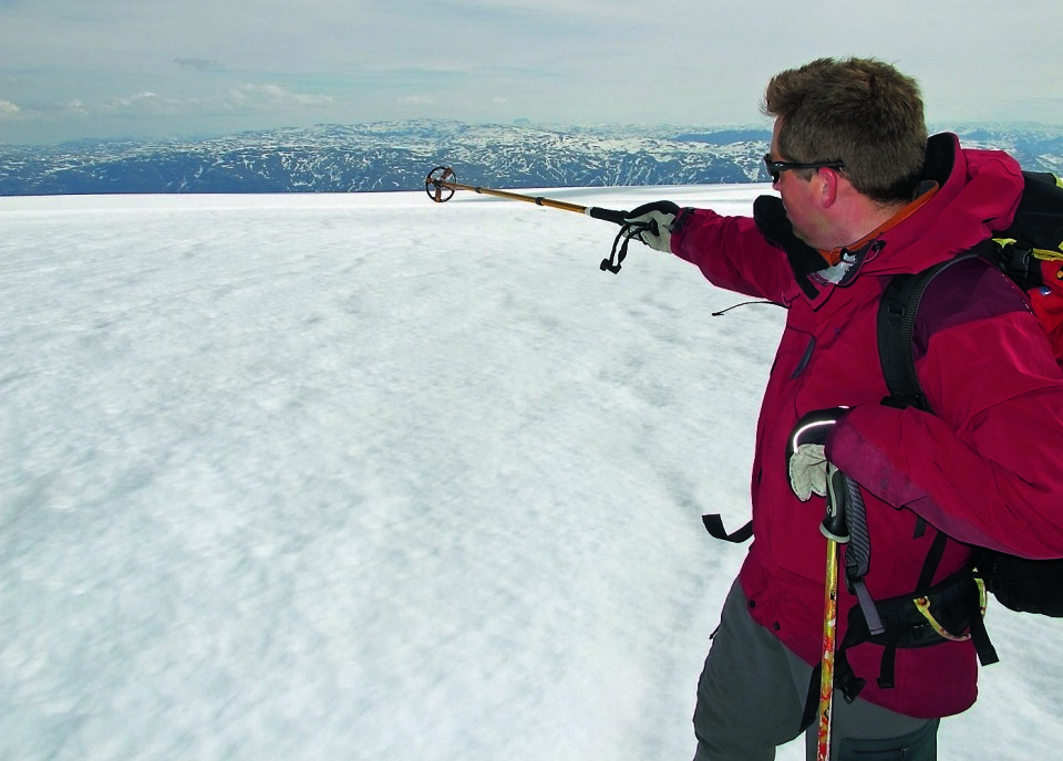 RETT VEST: Professor Jostein Bakke på toppen av den delen av fonna kjent som Nordfonna, 1644 meter over havet hvor isen er rundt 80 meter tykk. Her peker han i retning bassenget rett ovenfor Måge.
