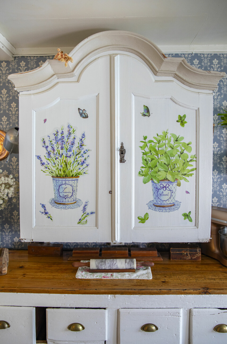 FRANSKINSPIRERT: Det gamle skapet var en topp til et lintøyskap. Dekoren av lavendel har Helen limt på. Den gamle kjøpmannsdisken sto ute på stabburet og var blytung å få inn. De valgte å seile den over isen på tunet en vinter, og fikk båret den inn.