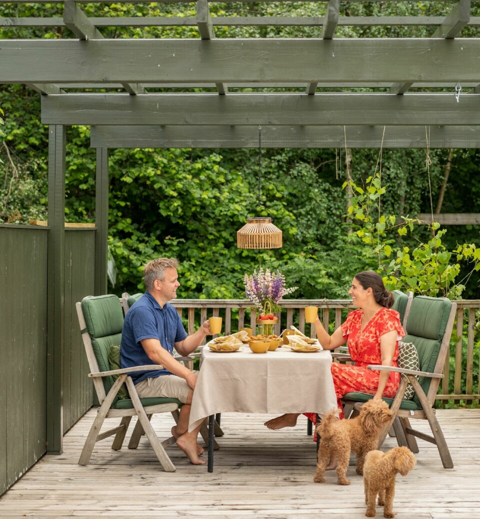 PAVILJONG: Under paviljongen på terrassen er det blitt spiseplass med bord og stoler de har arvet. Over bordet henger en solcellelampe fra Clas Ohlson, og rundt paviljongen vokser det drueranker.