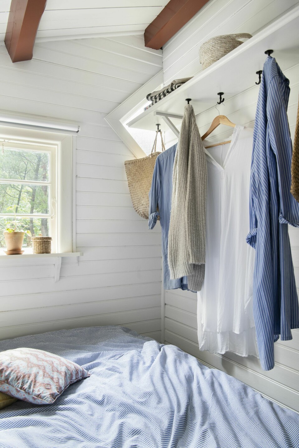 SMART GARDEROBE: For å utnytte plassen i det lille soverommet er det hengt opp en hylle med knagger under. Hyllen er laget av Frants. Sengetøyet er fra Juna, og puten er fra Helle Thygesen.