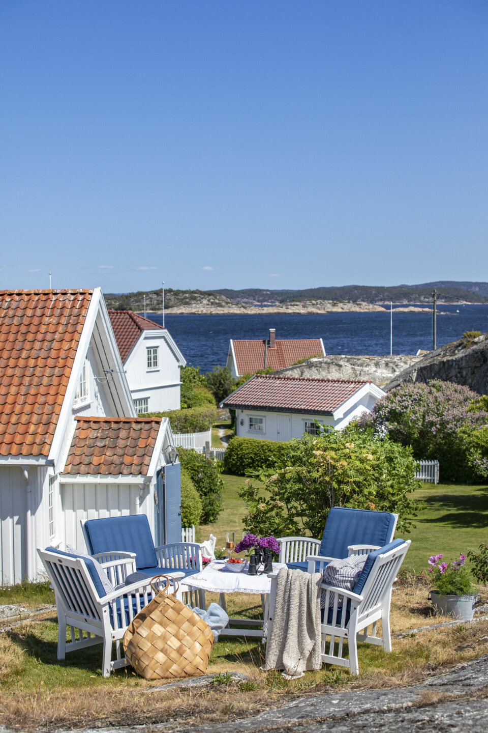 FLOTT PLASS: På en høyde ved hytta, med flott utsikt til alle kanter av øya, har familien en koselig sittegruppe. Her ser de hav og uendelig horisont.