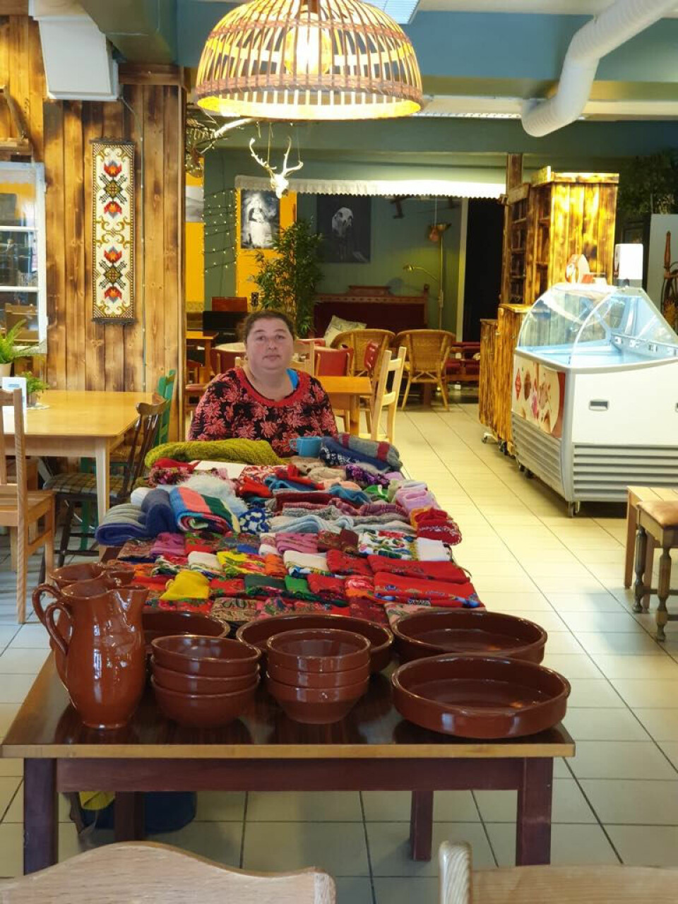 SELGER EGNE PRODUKTER: Lidia selger gjerne egne produkter. Hun har selv laget pottene i forkant på bildet. Både Lidia og Simona henter greiner i skogen og lager kurver som de selger.