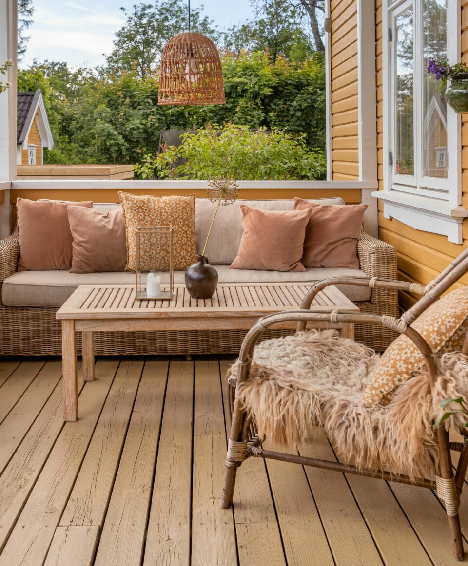 VERANDA: Når solen blir borte fra hagen, er det lett å bli sittende på verandaen, for her er det kveldssol. Sofaen og bordet er fra Brafab, mens stolen er kjøpt på Ellos. Taklampen har Anne Mette fått av en venninne.