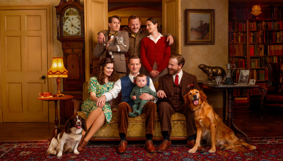 EN FIN GJENG: I midten sitter James Herriot med lille Jimmy og kona Helen. Til høyre Siegfried Farnon med den viltre broren Tristan i midten bak. På hver side av ham står husholdersken Mrs. Hall og dyrlege-assistenten Carmody.