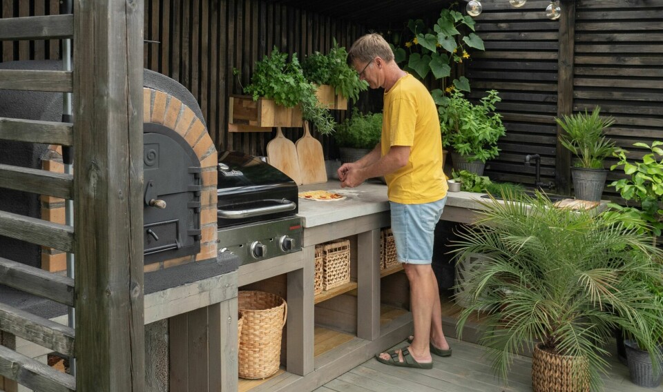 MATLAGING I DET FRI: Frode elsker å lage pizza utendørs. Det er en ekstra tilfredsstillende følelse når han har tegnet og bygget hele utekjøkkenet selv fra bunnen. – Kunne vi valgt på nytt så hadde vi planlagt et tak over. Det er ikke like gøy å kokkelere under en paraply.