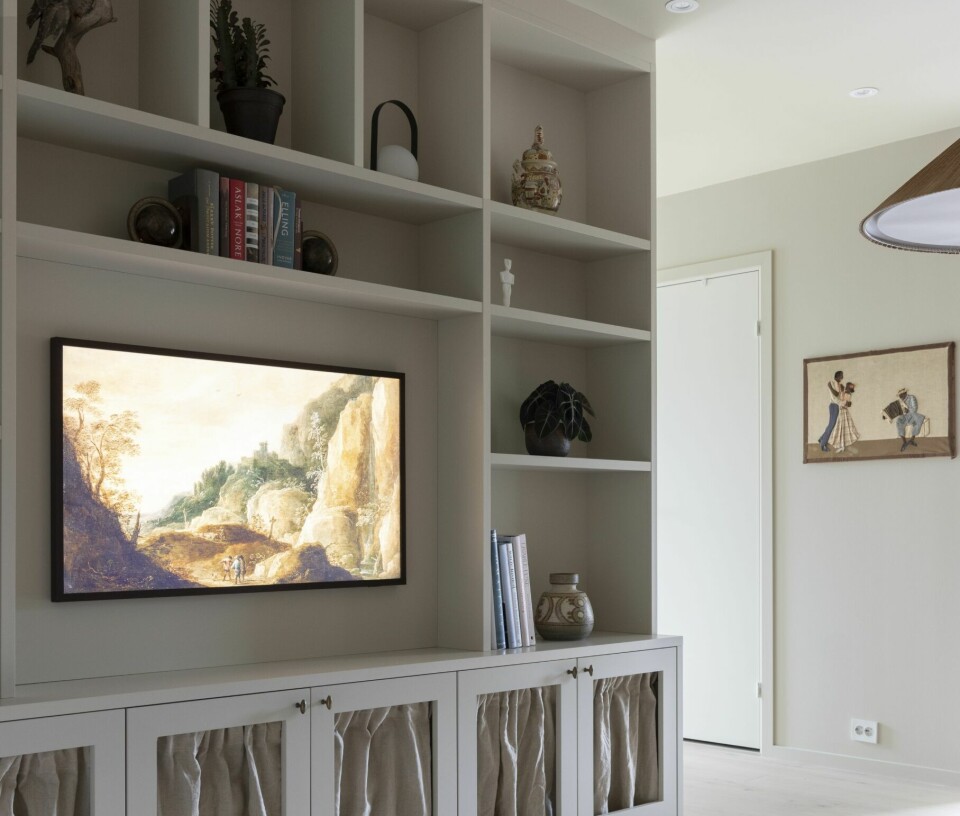 PLASSBYGGET: Bokhyllen er bygget av Elen Møbelstudio. Gardinene fra Kid var et bomkjøp til soverommet som ble sydd om til forheng i skapdørene. Grepene er fra Etsy. Tv-en er Samsungs The Frame. Det meste i hyllen er bruktfunn og arvegods. Gulvteppet er fra Layered.