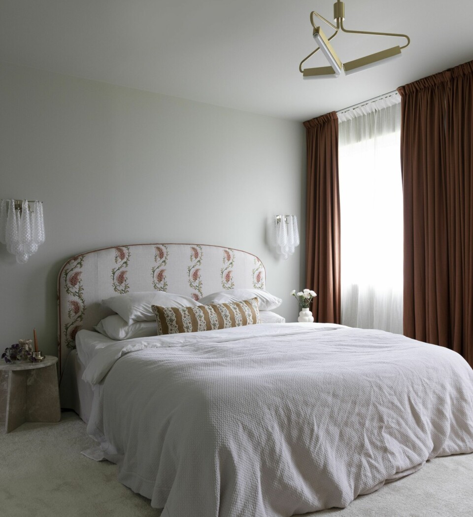 EN DRONNING VERDIG: Det lekre soverommet har sengegavl laget i tekstil fra Colefax & Fowler etter eget design via Angleterre. Veggen er malt i fargen Pale Linden fra Jotun. Sengekappen er fra Mille Notti og teppegulvet er fra Teppeabo. De terrakottafargede gardinene er fra Gotain, de gjennomsiktige fra Jotex. Taklampen er fra Rubn Lighting.
